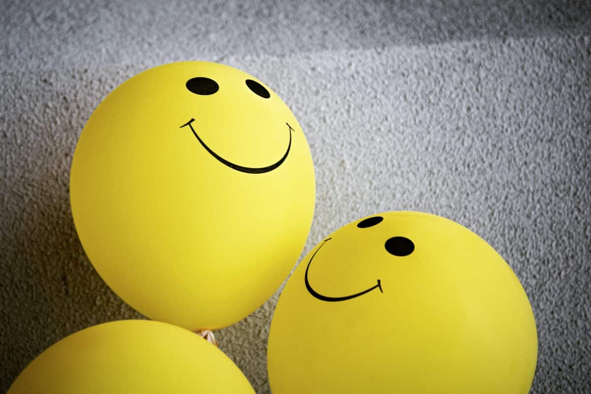 Three yellow smiley face balloons indicating personal impact